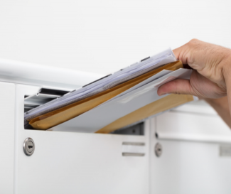 Hand placing mail in mail slot