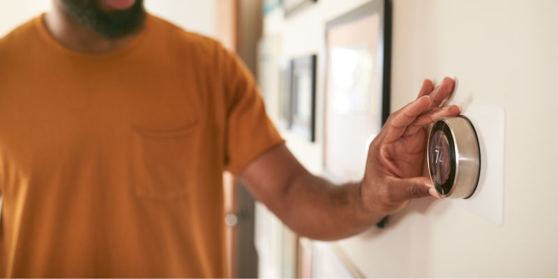 Person adjusting digital thermostat